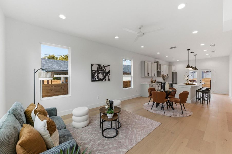 Living area with a ceiling fan, healthy amount of natural light, recessed lighting, and light wood finished floors