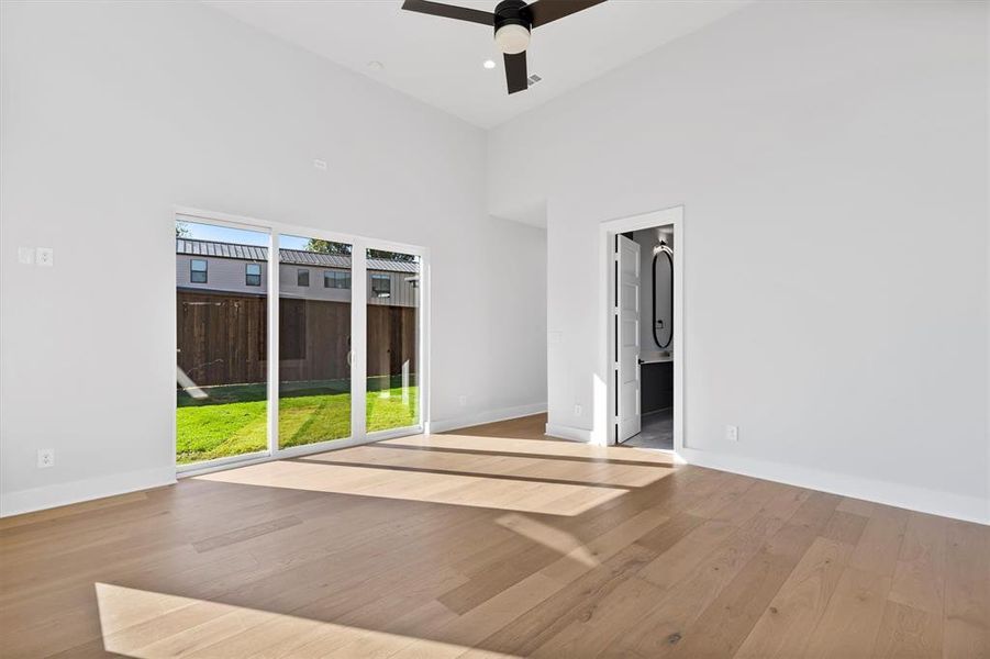 Spare room featuring a towering ceiling, light hardwood / wood-style flooring, and ceiling fan