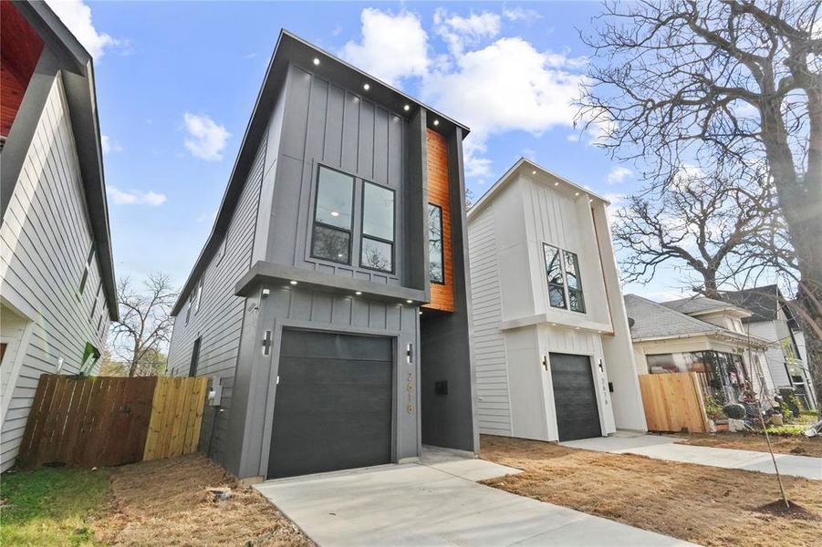 Contemporary home with board and batten siding, an attached garage, and driveway Contemporary home with board and batten siding, an attached garage, and driveway