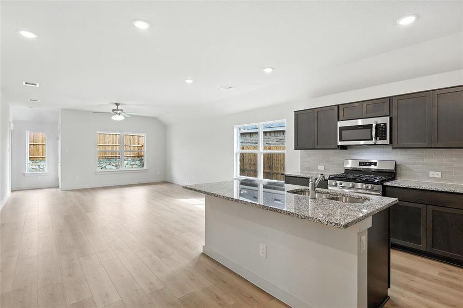 Kitchen with appliances with stainless steel finishes, plenty of natural light, a kitchen island with sink, ceiling fan, and recessed lighting