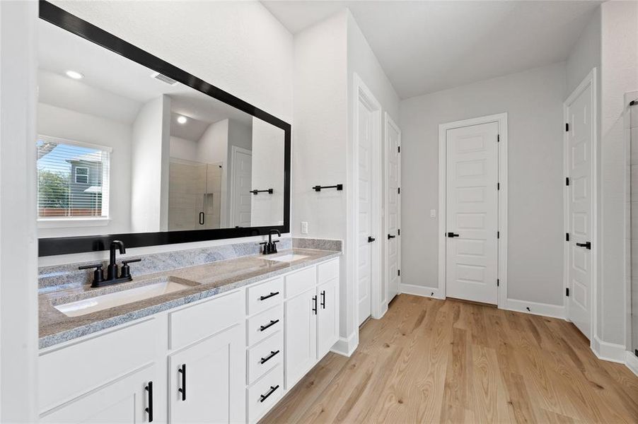 Master bathroom includes his/her closets, granite countertop, elongated mirror, and dual-vanity sinks.