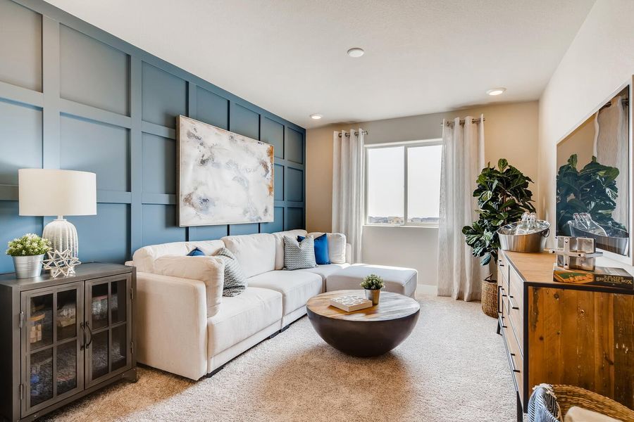 A living room with a white couch and a round table.