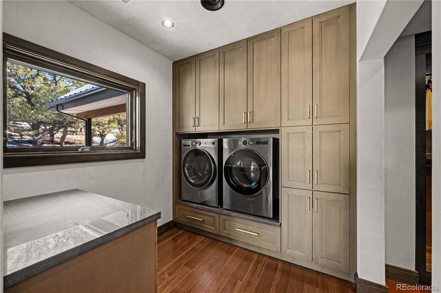 Primary bathroom spa with custom cabinets and washer/dryer Primary bathroom spa with custom cabinets and washer/dryer