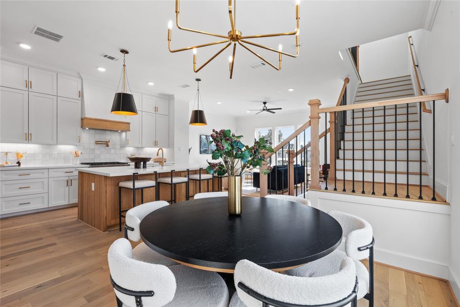 The adjacent dining area offers cozy seating, while the stylish staircase adds a touch of sophistication.