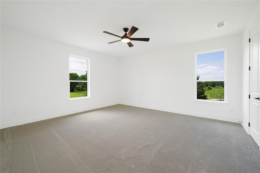 Empty room with light carpet and ceiling fan