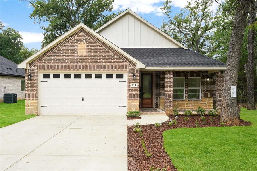 Brick exterior featuring stone accents and a covered front porch Brick exterior featuring stone accents and a covered front porch