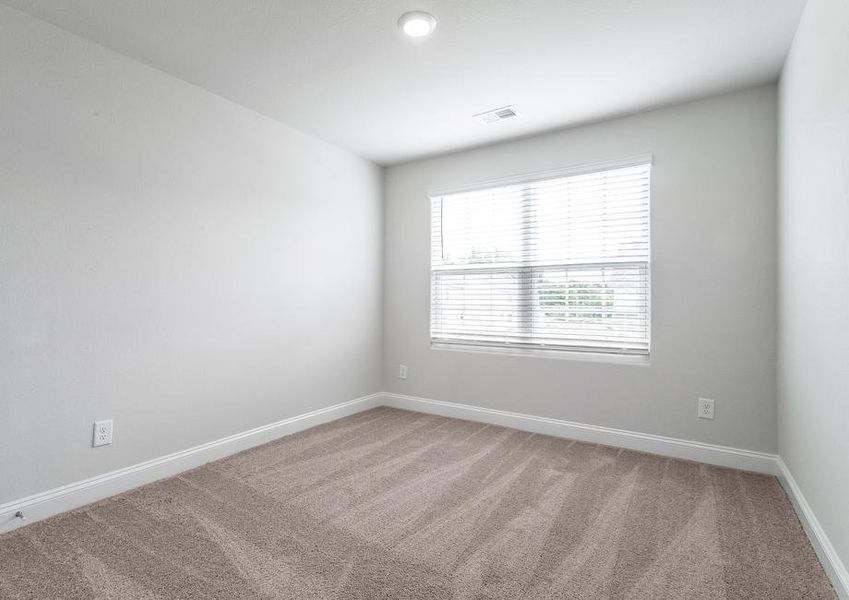 Secondary bedroom with carpet.