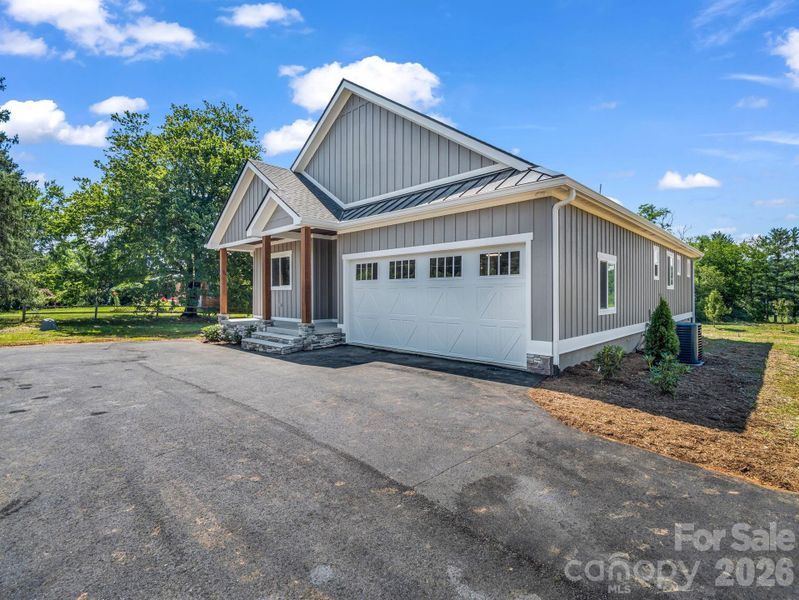 Front view of custom modern farmhouse, 2 car attached garage, covered front porch and hardyboard siding, oversized driveway for ample parking Front view of custom modern farmhouse, 2 car attached garage, covered front porch and hardyboard siding, oversized driveway for ample parking