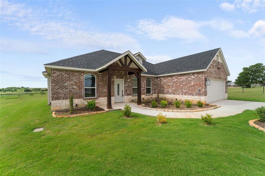 Craftsman inspired home with a garage and a front lawn