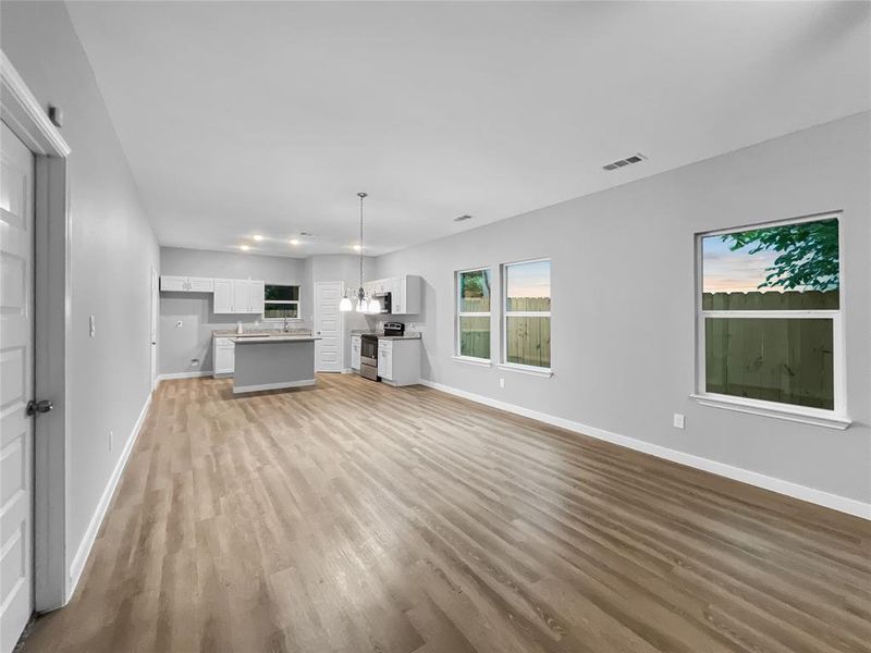 Unfurnished living room with light hardwood / wood-style flooring and an inviting chandelier