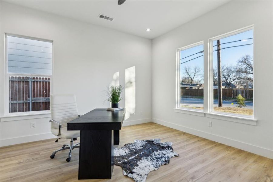 Office with wood-type flooring and a healthy amount of sunlight