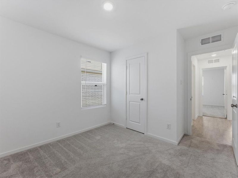 Room featuring light gray carpeting, white walls, a window with horizontal blinds, a white interior door, and a recessed ceiling light