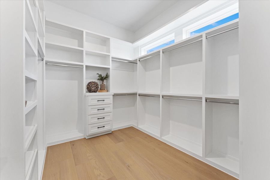Expansive his or hers walk-in closet with ample shelving and natural light. Expansive his or hers walk-in closet with ample shelving and natural light.