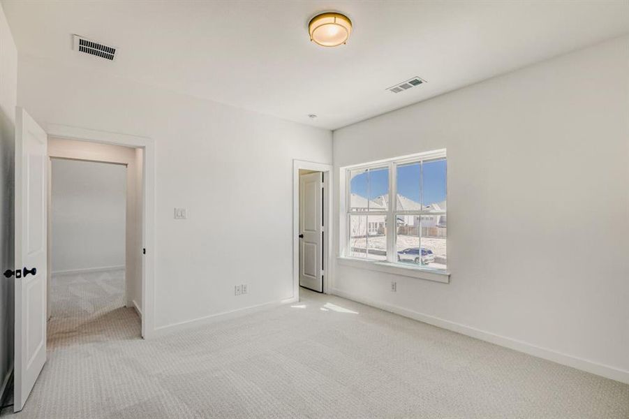 Unfurnished bedroom with light colored carpet