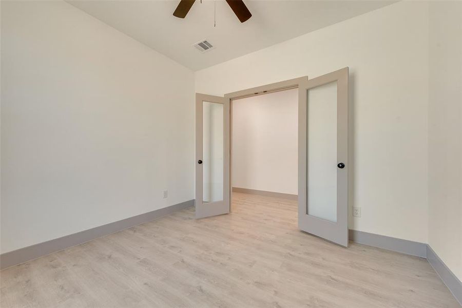 Empty room with ceiling fan and light hardwood / wood-style flooring