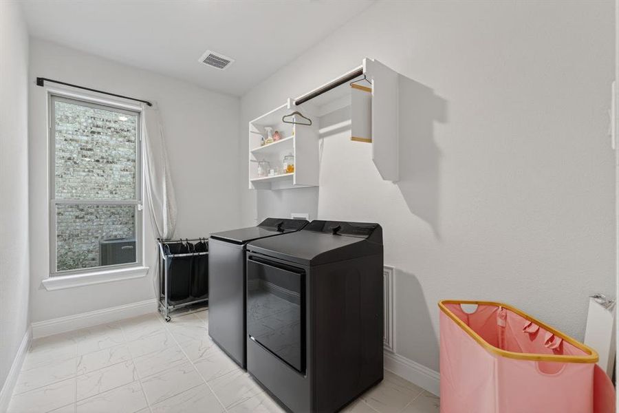 Laundry room with light marble finish floors and washing machine and dryer Laundry room with light marble finish floors and washing machine and dryer