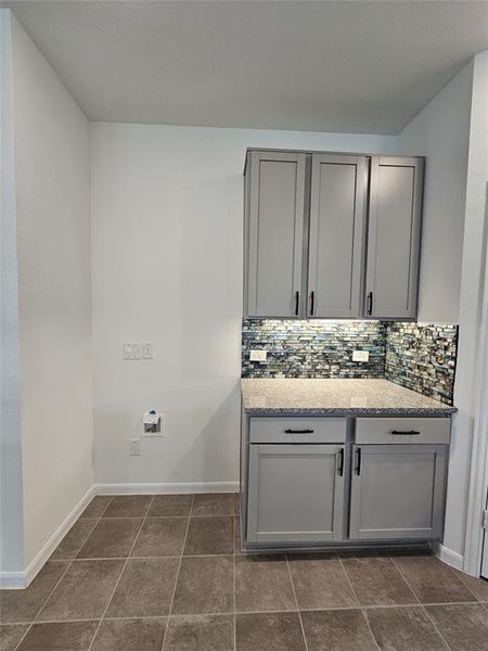 Bathroom featuring backsplash, tile patterned floors, and vanity