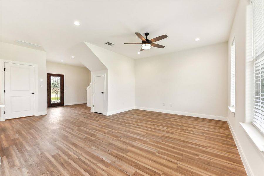 Living space featuring light wood-type flooring, baseboards, visible vents, recessed lighting, and ceiling fan Living space featuring light wood-type flooring, baseboards, visible vents, recessed lighting, and ceiling fan