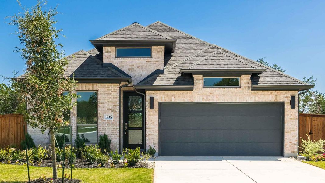 French country home with a shingled roof, stone siding, and driveway French country home with a shingled roof, stone siding, and driveway