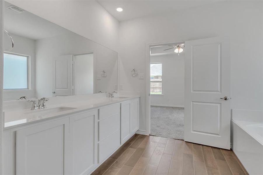 Master Bathroom with dual vanity, hardwood / wood-style floors, and independent shower and bath