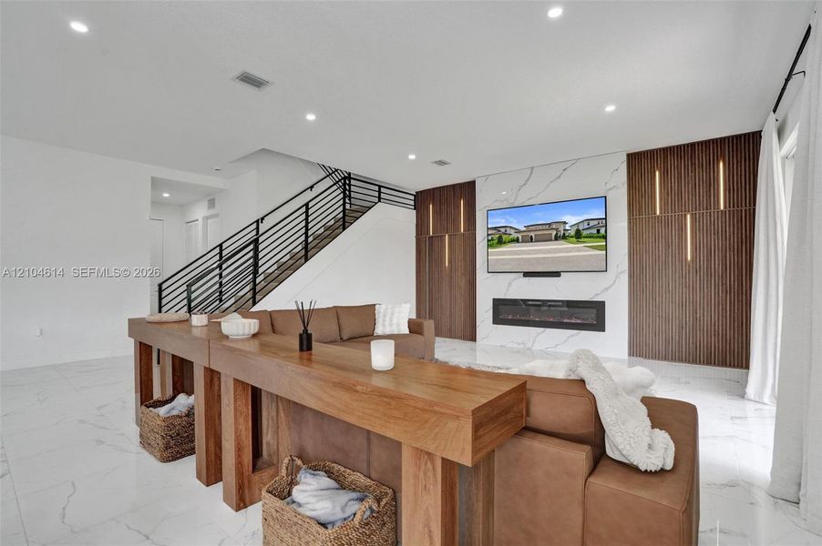 Modern white tile flooring, recessed lighting, and a contemporary linear fireplace