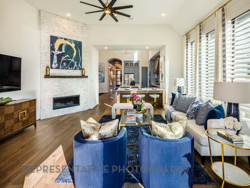Living area with wood finished floors, a ceiling fan, a stone fireplace, recessed lighting, and arched walkways Living area with wood finished floors, a ceiling fan, a stone fireplace, recessed lighting, and arched walkways