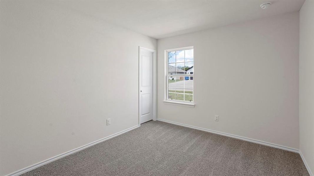 Interior space featuring light gray carpeting, white baseboards, and neutral wall paint