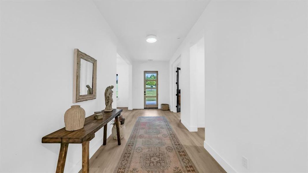 Hallway with light wood-type flooring and baseboards Hallway with light wood-type flooring and baseboards