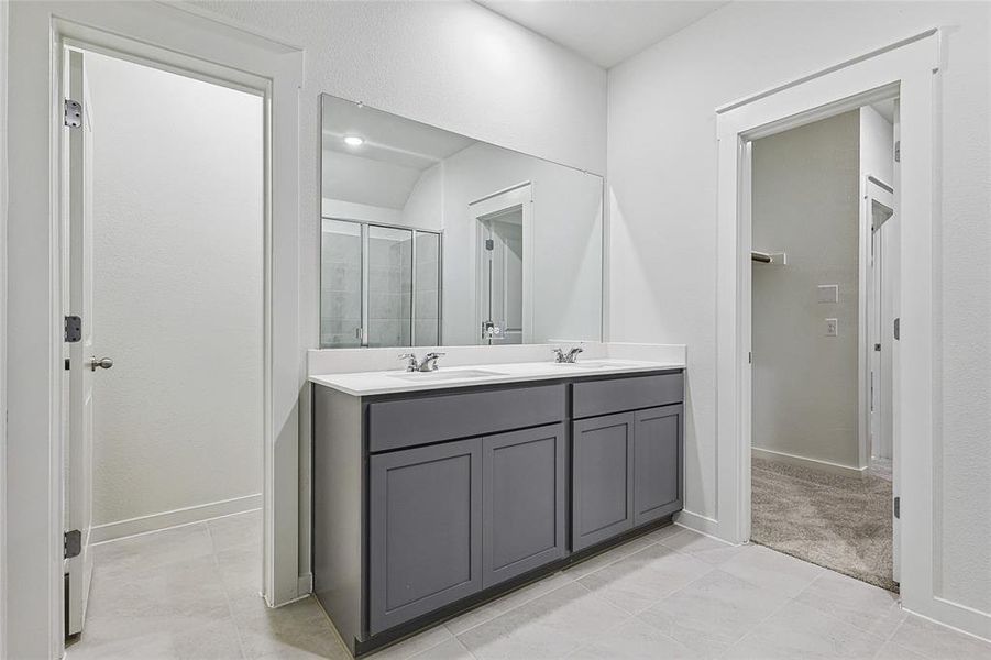 Bathroom featuring tile patterned floors, vanity, and walk in shower