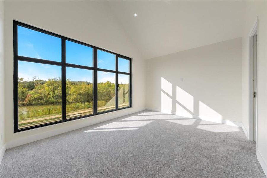 Spare room with light carpet and high vaulted ceiling Spare room with light carpet and high vaulted ceiling