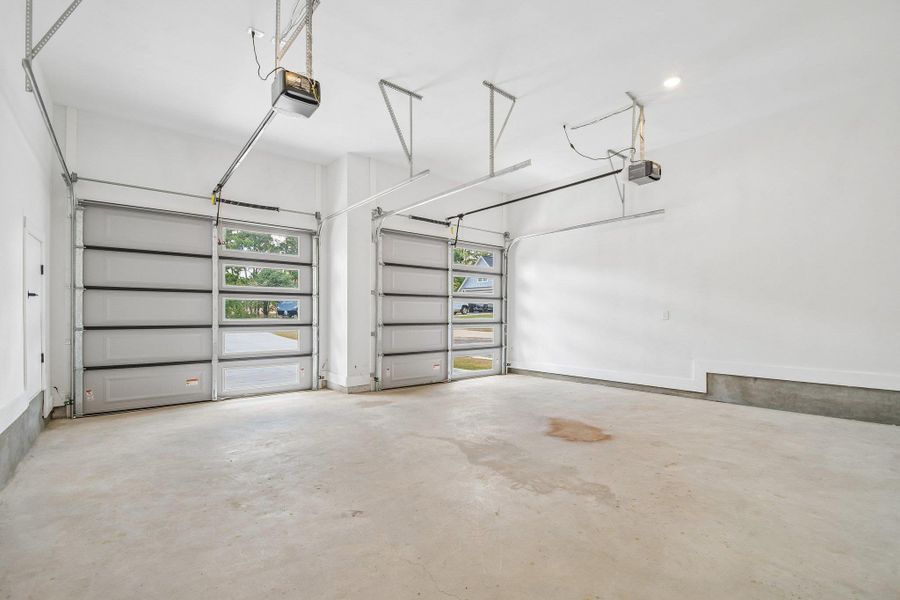 Clean concrete flooring and automatic door openers define this functional multi-car parking space. Clean concrete flooring and automatic door openers define this functional multi-car parking space.