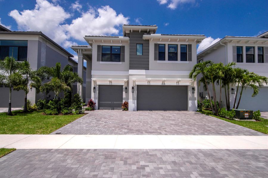 Front exterior of a new home in Apex at Avenir, Palm Beach Gardens, FL, highlighting curb appeal (Image 26). Front exterior of a new home in Apex at Avenir, Palm Beach Gardens, FL, highlighting curb appeal (Image 26).