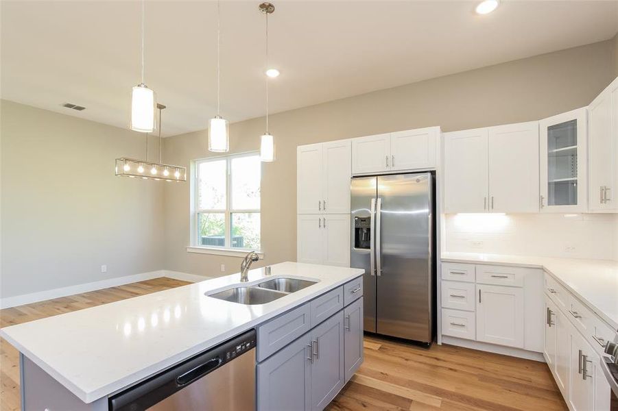 Kitchen with white cabinetry, sink, and appliances with stainless steel finishes