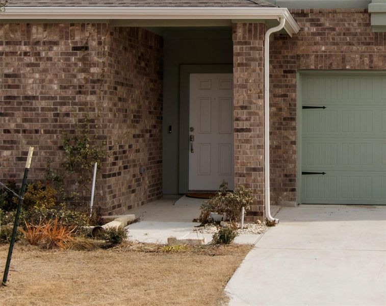 Charming covered brick entry, combining classic design with an elevated perspective of the home’s exterior.