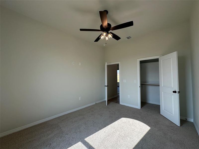 Unfurnished bedroom featuring carpet floors, a ceiling fan, and a closet