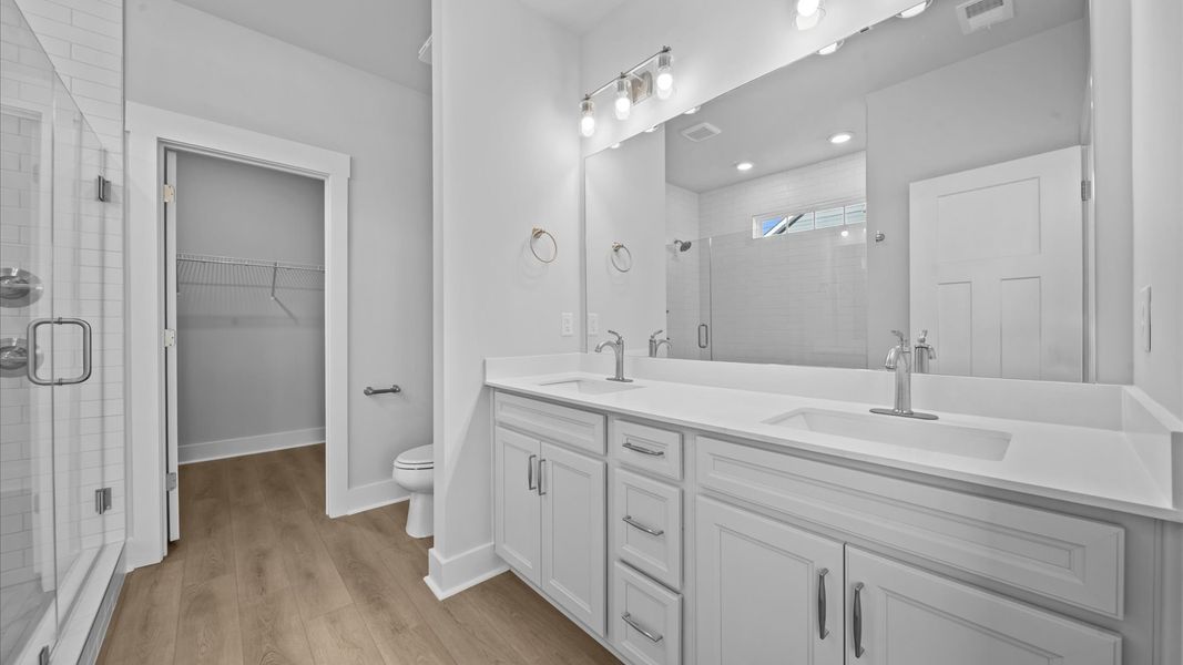 Superior en-suite primary bathroom with stylish dual vanity and tiled walk-in shower crafted with high standards in mind