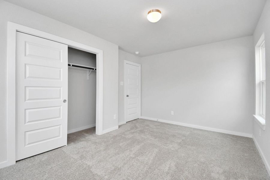 generously sized secondary bedrooms, showcasing 5-panel doors with modern hardware, large windows adorned with privacy blinds, and spacious closets boasting sleek and contemporary finishes. Sample photo of completed home with same plan. Actual colors and selections may vary. generously sized secondary bedrooms, showcasing 5-panel doors with modern hardware, large windows adorned with privacy blinds, and spacious closets boasting sleek and contemporary finishes. Sample photo of completed home with same plan. Actual colors and selections may vary.
