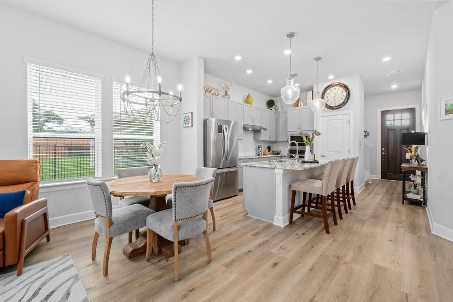 Dining space with recessed lighting, baseboards, a notable chandelier, and light wood-style floors Dining space with recessed lighting, baseboards, a notable chandelier, and light wood-style floors