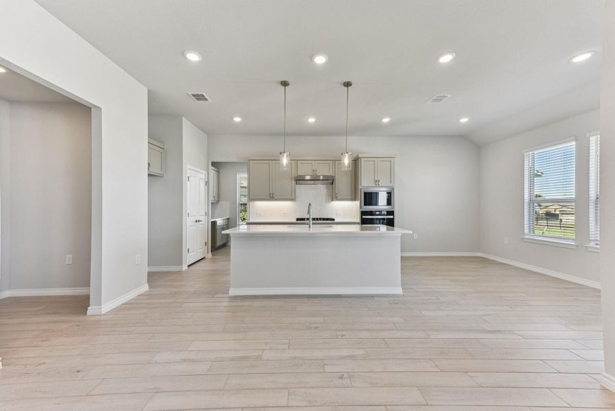 Kitchen featuring recessed lighting, a kitchen island with sink, light wood-type flooring, hanging light fixtures, and oven Kitchen featuring recessed lighting, a kitchen island with sink, light wood-type flooring, hanging light fixtures, and oven