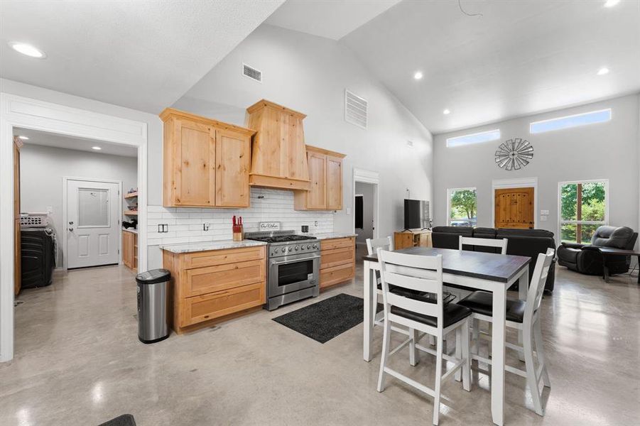 Knotty alder cabinetry in kitchen with a 6 burner commercial gas stove and oven.