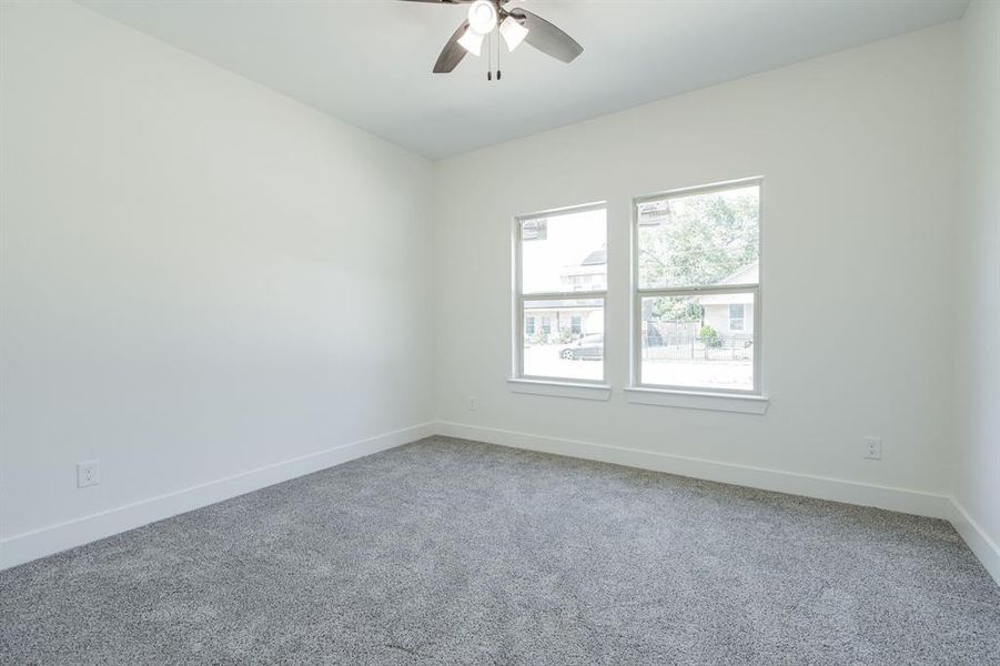 Carpeted spare room featuring ceiling fan