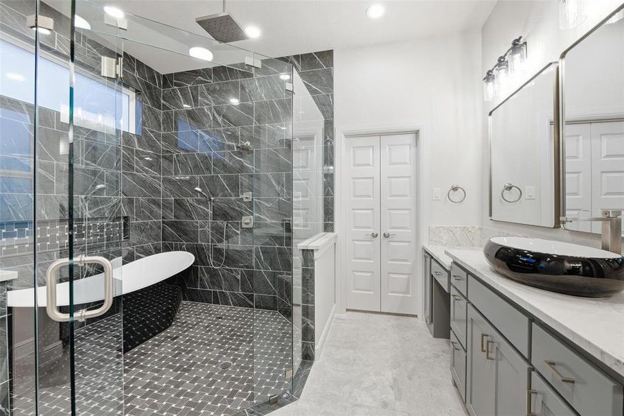 Bathroom with vanity, a shower stall, a soaking tub, and light tile patterned floors Bathroom with vanity, a shower stall, a soaking tub, and light tile patterned floors