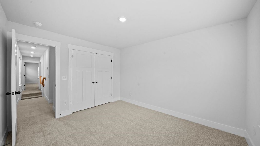 Accomplished bedroom layout with cozy carpet, a spacious walk-in closet, and sun-filled windows Accomplished bedroom layout with cozy carpet, a spacious walk-in closet, and sun-filled windows