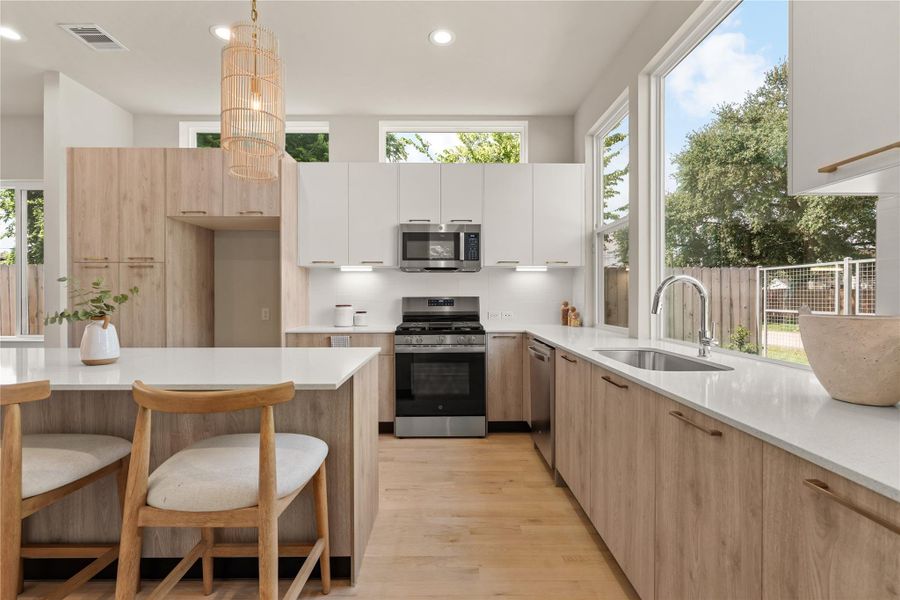 Welcoming entry that opens to a spacious kitchen anchored by a large island & elegant pendant lighting, setting the tone for the home’s bright, modern design.
