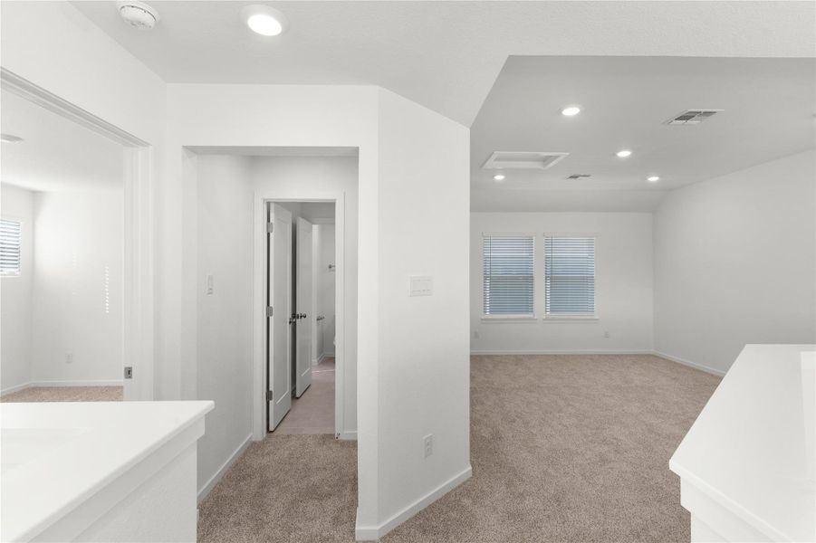 Hallway featuring light carpet, recessed lighting, and baseboards