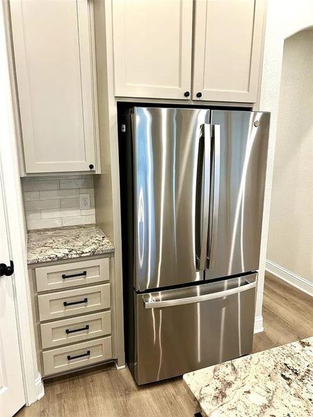 Stainless steel French door refrigerator set within custom cabinetry Stainless steel French door refrigerator set within custom cabinetry
