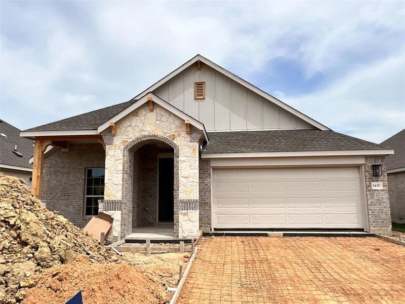 View of front of home with roof with shingles, a garage, and decorative driveway