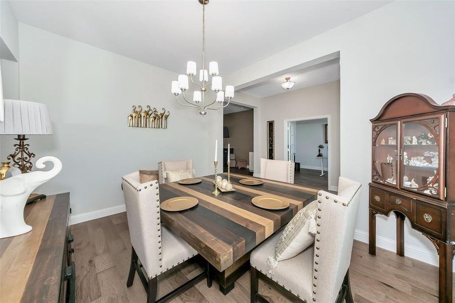 Dining space with wood-type flooring and a chandelier