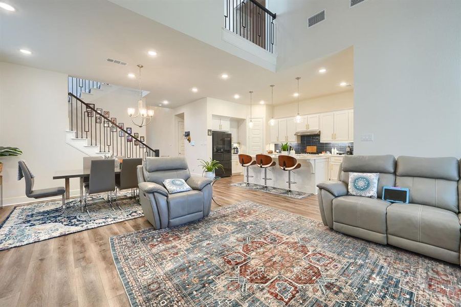 Living room with a notable chandelier and light hardwood / wood-style flooring