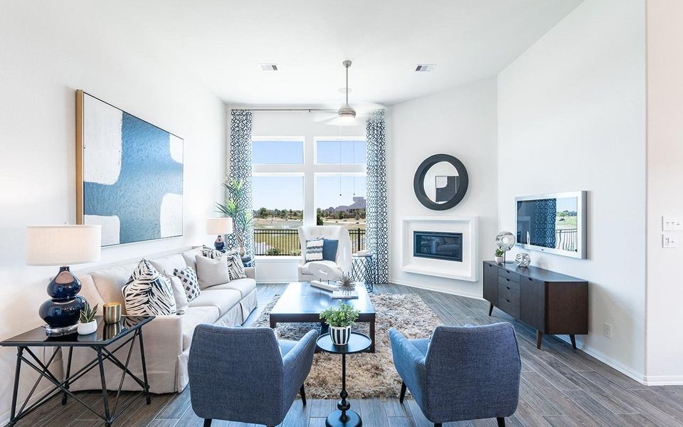 Living area with a glass covered fireplace, a ceiling fan, baseboards, and wood finished floors Living area with a glass covered fireplace, a ceiling fan, baseboards, and wood finished floors